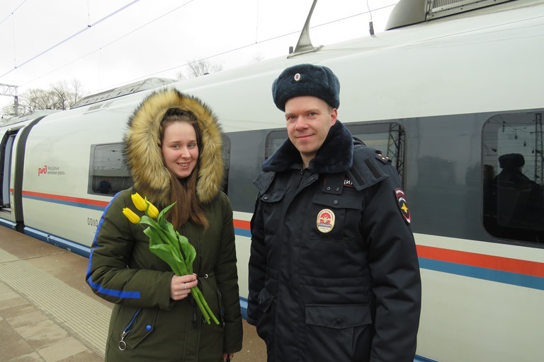 На железнодорожном вокзале Твери транспортные полицейские вручают женщинам цветы